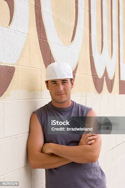 Giovane Uomo Appoggiato Sulla Parete - Fotografie stock e altre immagini di All'indietro - All'indietro, Cappello, Uomini