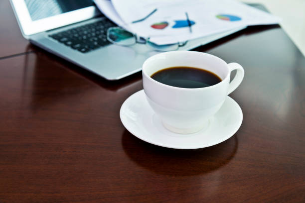 istock Coffee cup and office supplies on table 957980084