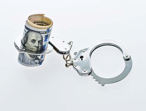 US dollar bills in handcuffs.