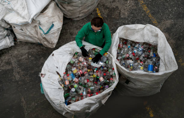 Throwing a plastic bottle into a bin to recycle view from below, environmental conservation and protection concept