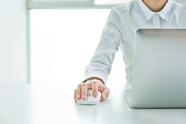 Businesswoman hands on a mouse and keyboard.