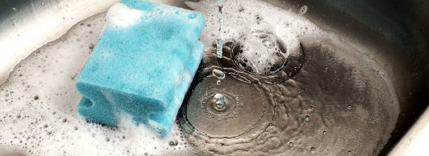 istock sponge in kitchen sink under dripping water, suitable for header or banner 957994742
