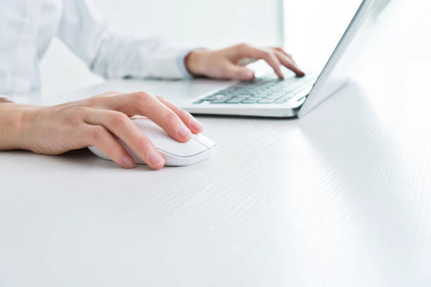 Businesswoman hands on a mouse and keyboard.