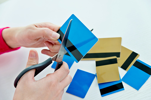 Woman hands cutting a credit card.