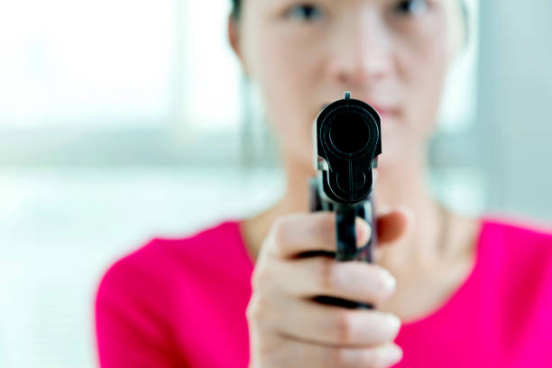 Woman holding a gun indoors.