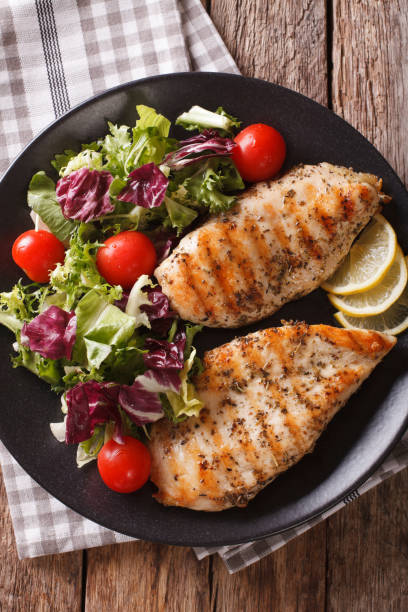 istock Grilled chicken breast with mixed salad close-up. Vertical top view 958002938