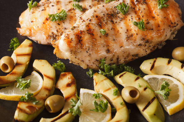 istock Grilled chicken breast with avocado, lemon and olive macro. Horizontal top view 958004906