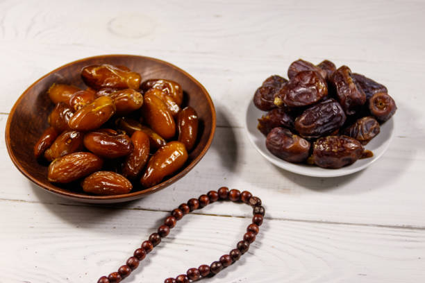 istock Dates fruit and prayer beads on white wooden table 958007988