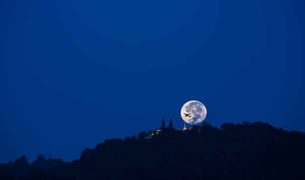 istock silhouette shot image of big moon and plane shadow 958013082