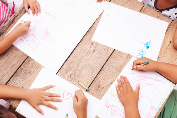 istock Children's hands drawing with colored pencils on wooden table,concept education background. 958016060