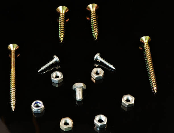 A many screws and bolts in arrangement as face with hairs, eyes, nose and mouth A many screws and bolts in arrangement as face with hairs, eyes, nose and mouth on the black background hit the nail on the head stock pictures, royalty-free photos & images