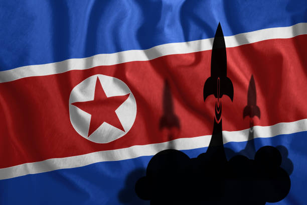 ロケットは韓国北朝鮮の旗は、風になびくの背景に飛ぶ。北朝鮮のカラフルな国旗。愛国心、愛国心が強い記号、北朝鮮の核プログラムです。 - violent wind ストックフォトと画像