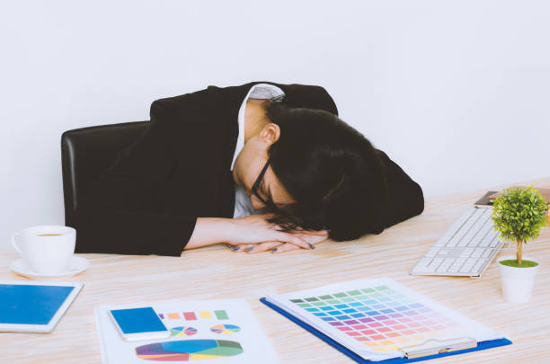 istock business woman sleeping on table in workplace because tired with over workload or napping because laziness with working. 958017986