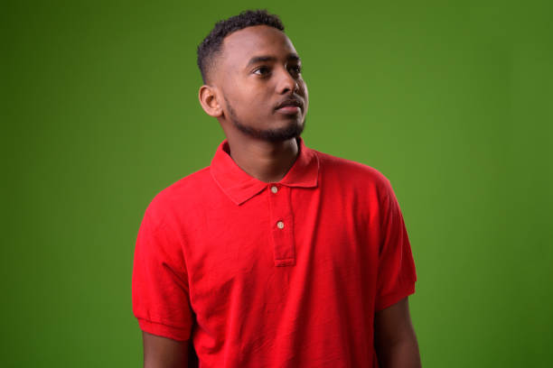 istock Young handsome African man against green background 958030558