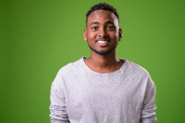 istock Young handsome African man against green background 958030992