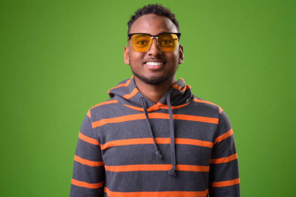 istock Young handsome African man against green background 958031318
