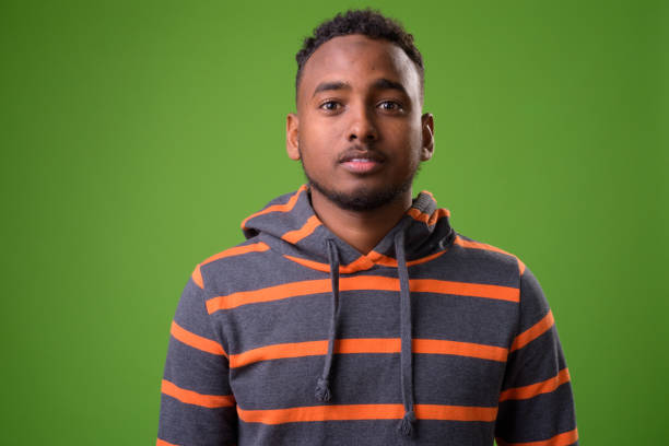 istock Young handsome African man against green background 958031576