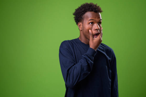 istock Young African man against green background 958034636