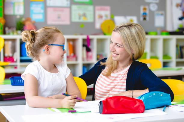 istock beautiful teacher helps her student to learn 958037904