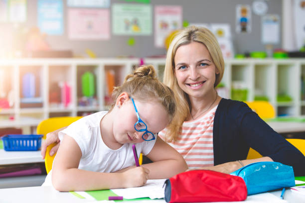 istock beautiful teacher helps her student to learn 958037922