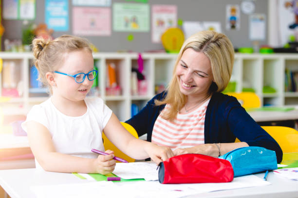 istock beautiful teacher helps her student to learn 958037948