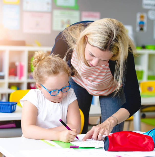 istock beautiful teacher helps her student to learn 958037966