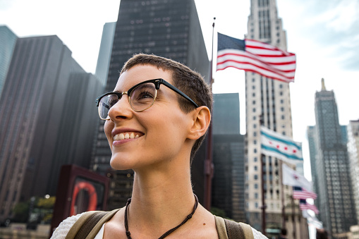 American Young woman in downtown Chicago and US flag