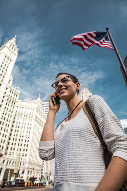 istock American Young woman in downtown Chicago and US flag 958038310