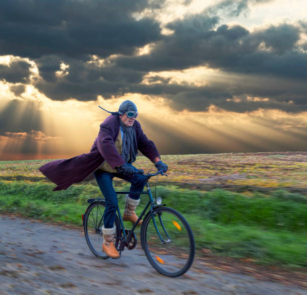 último homem vestindo couro capacete e retro aviador óculos ciclismo com sopro casaco sob skyscape dramática - men hat leather senior adult - fotografias e filmes do acervo