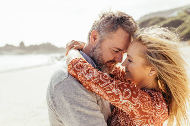 istock Loving senior couple embracing on the beach 958044100