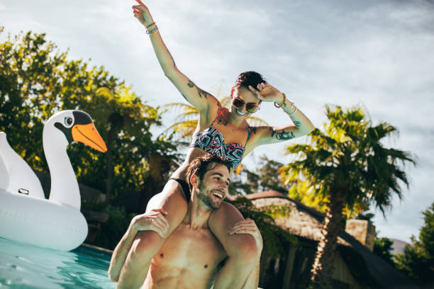 istock Couple enjoying a summer day in swimming pool 958044814