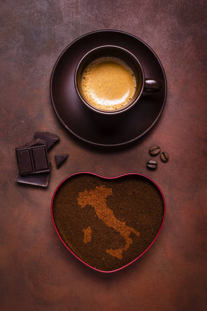 composition with a cup of espresso, a bowl of ground coffee and embossed the shape of Italy