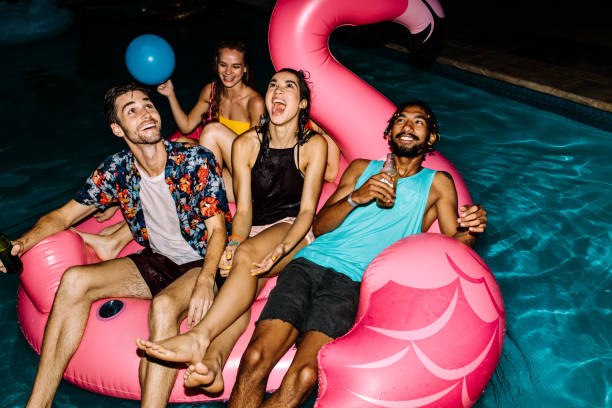 amigos de fiesta en la piscina - fiestas en la piscina de noche fotografías e imágenes de stock