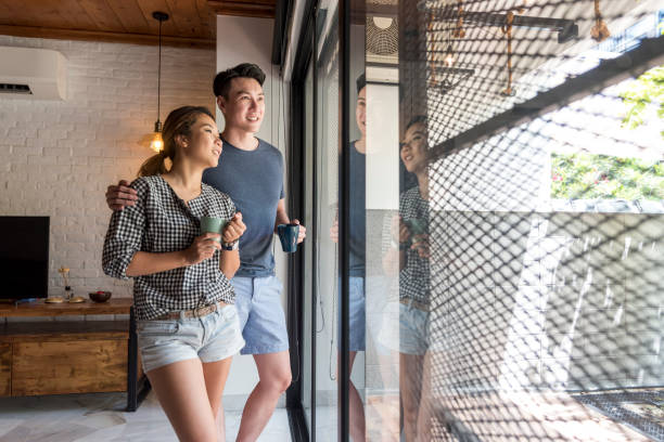 istock Couple standing by the window 958048938