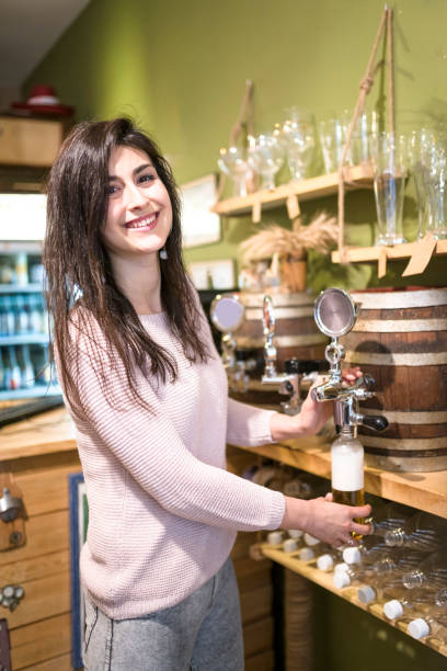 istock Sales assistant pouring lager from beer barrel 958049450