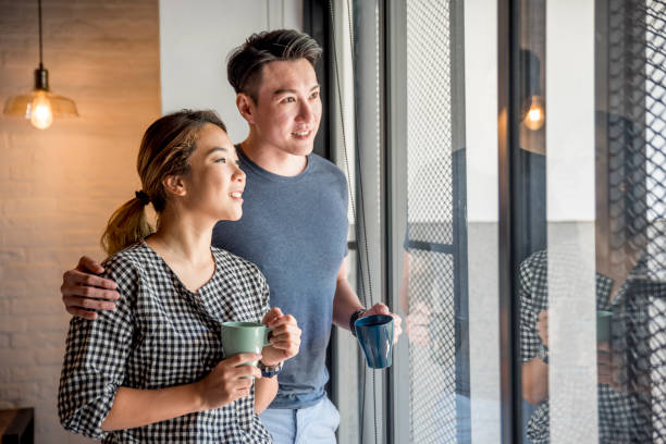 istock Couple standing by the window 958050354