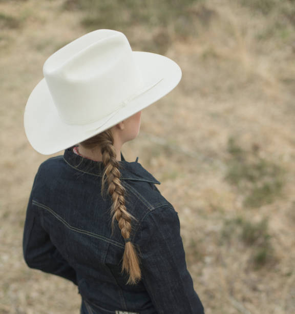 istock Cowgirl in jeans jacket standing in field. High angle view. 958050876