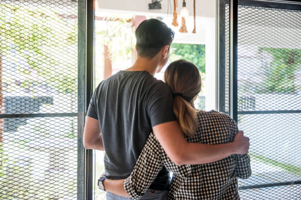 istock Couple standing by the window 958051372