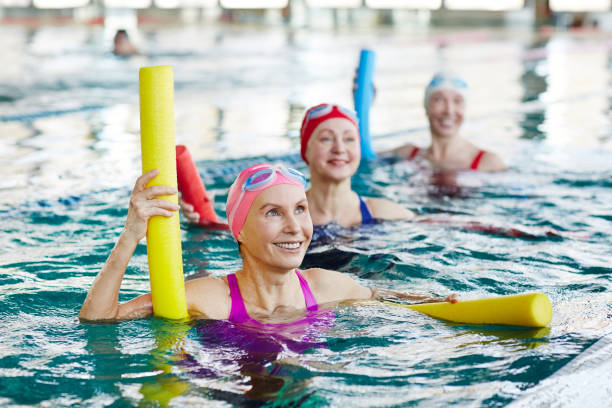 wassergymnastik im schwimmbad - bademütze stock-fotos und bilder