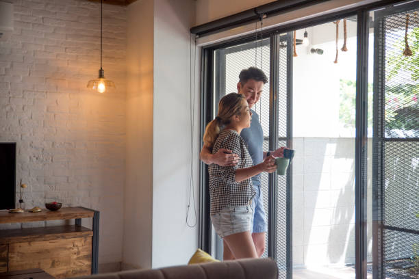 istock Couple standing by the window 958053808