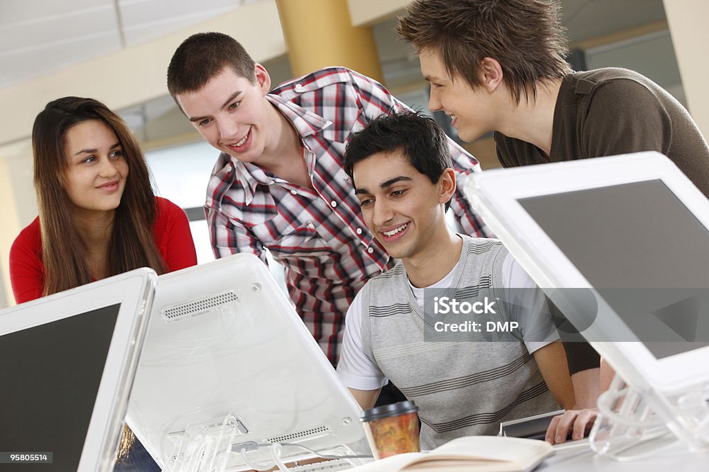 Os estudantes trabalhando juntos em um computador na escola, sala de aula - Foto de stock de 16-17 Anos royalty-free