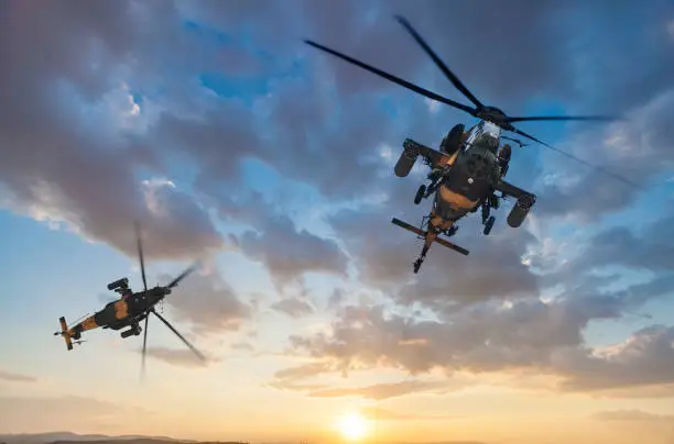 Attack Helicopters flying against dramatic sky at sunset
