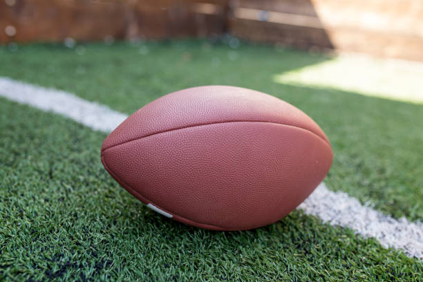 istock Rugby helmet with ball on green grass 958055732