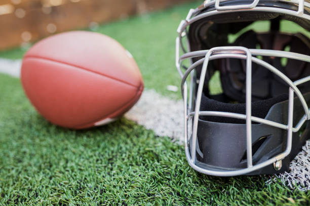istock Rugby helmet with ball on green grass 958055786