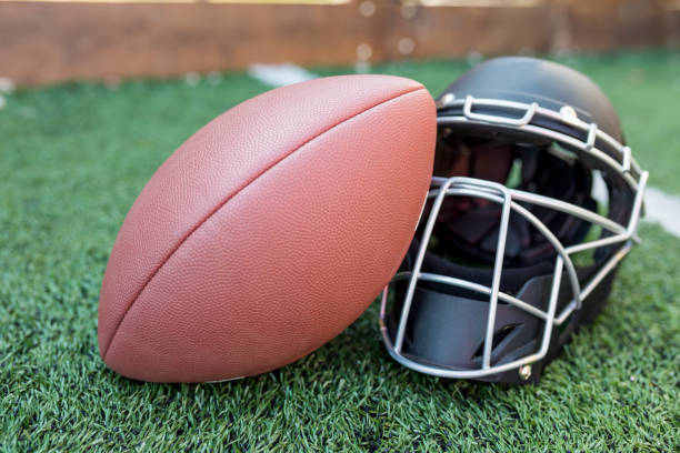 istock Rugby helmet with ball on green grass 958056056