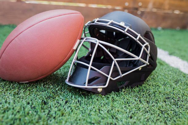 istock Rugby helmet with ball on green grass 958056444