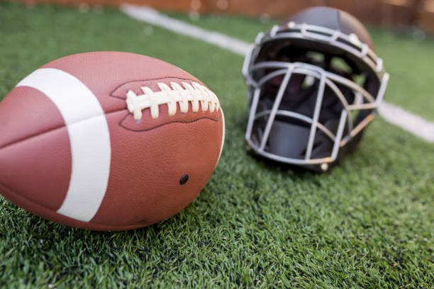 istock Rugby helmet with ball on green grass 958056488