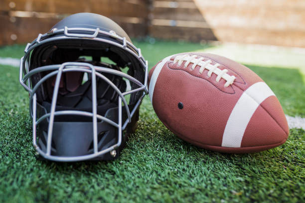 istock Rugby helmet with ball on green grass 958056874