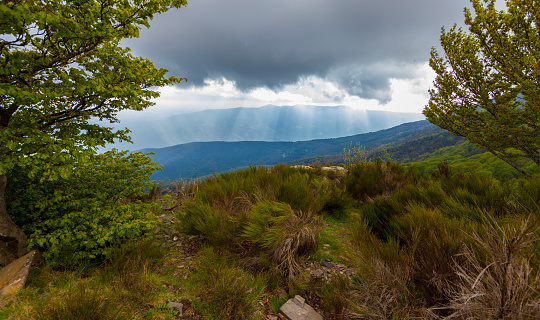 Montseny western views from Turó de L'Home road, sun between the clouds make beatuiful light pattern in the sky