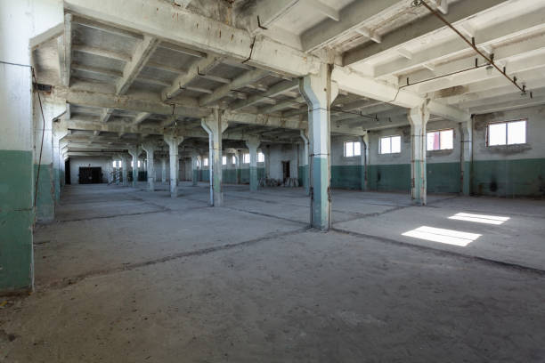 istock Industrial warehouse with cement walls, floors, windows and pillars before construction, remodeling, renovation, extension, restoration, reconstruction. Industrial background. 958065086